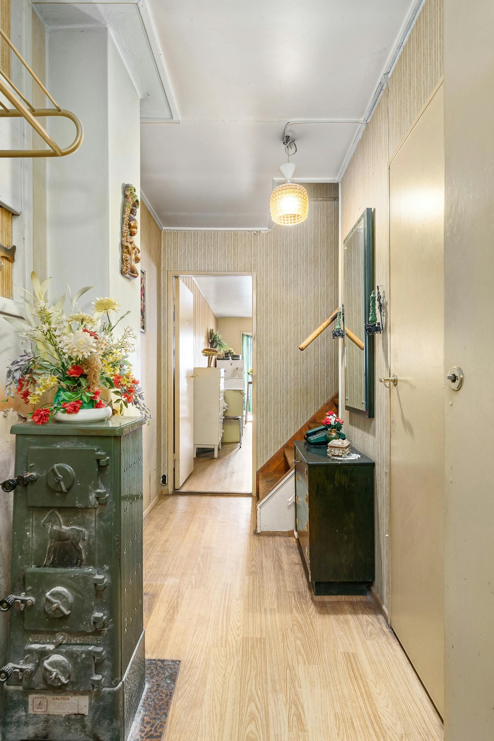 A welcoming vintage corridor adorned with vibrant floral arrangements and classic wooden furnishings.